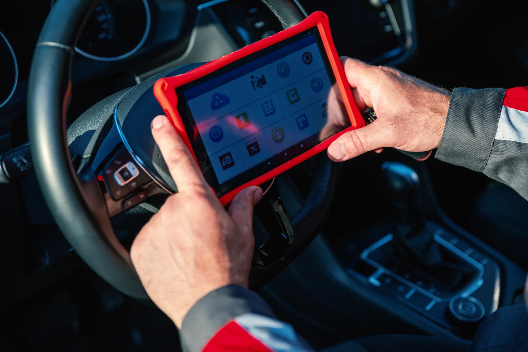 Technician using a diagnostic tablet inside a European vehicle